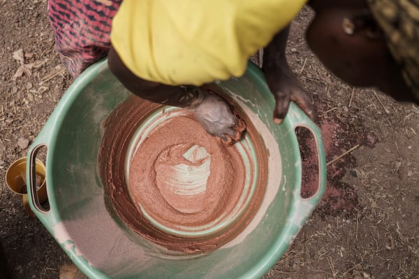 Sadio Camara, a gold processor, mixes mercury into sediment without using protective equipment at her home in the Kedougou region of Senegal on Thursday, Jan. 16, 2025. (AP Photo/Annika Hammerschlag)