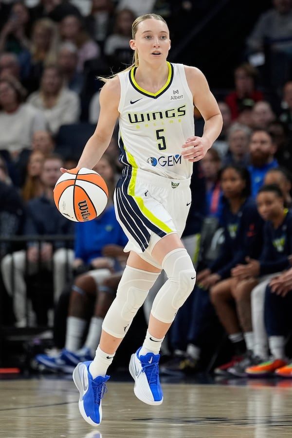 Dallas Wings guard Paige Bueckers (5) dribbles down the court during the first half of a WNBA basketball game against the Minnesota Lynx, Wednesday, May 21, 2025, in Minneapolis. (AP Photo/Abbie Parr)
