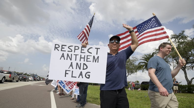 Protesters upset with players kneeling during the national anthem stand along a road leading to Raymond James Stadium before an NFL football game between the Tampa Bay Buccaneers and the New York Giants last Sunday. AP Photo/Phelan M. Ebenhack