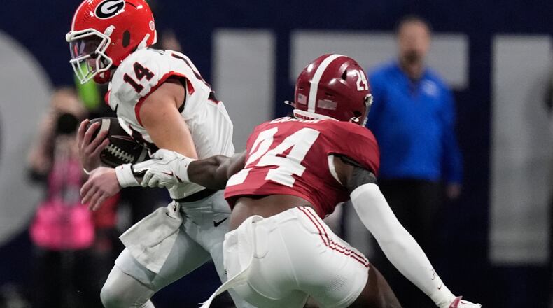 Georgia quarterback Gunner Stockton runs against Alabama linebacker Noah Carter during the first half of a Southeastern Conference championship NCAA college football game, Saturday, Dec. 6, 2025, in Atlanta. (Mike Stewart/AP)