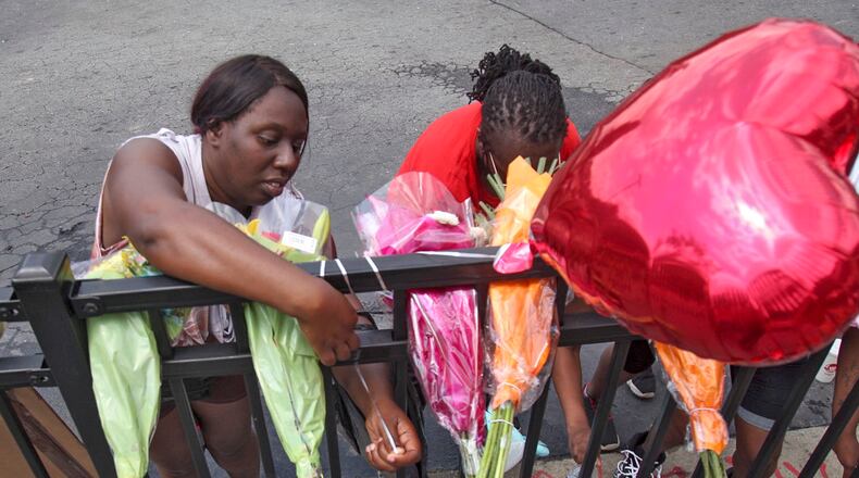 People began showing up at Wendy's on University Avenue Sunday morning, June 14, 2020. Some helped with cleanup, some came to look, and some began placing flowers and created a memorial. (Photo: Steve Schaefer for The Atlanta Journal-Constitution)