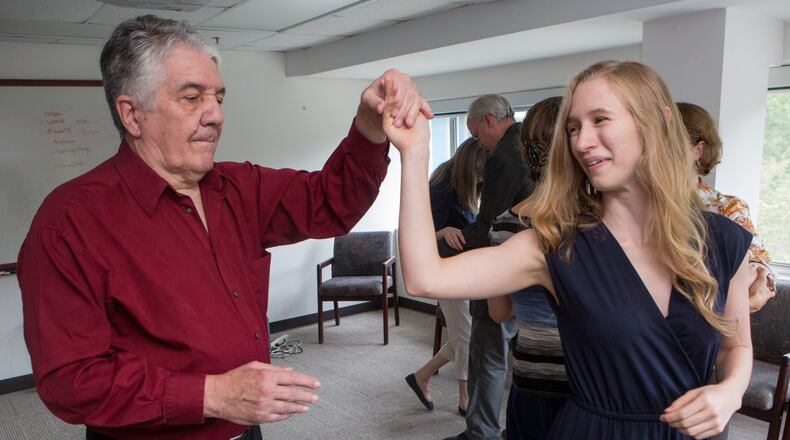 “Repeated studies have shown that adapted tango improves balance, mobility, endurance … spatial cognition and quality of life,” says Madeleine Hackney. Here, Larry Bullard twirls Ariel Hart during a dance therapy group session. (Photo by Phil Skinner)
