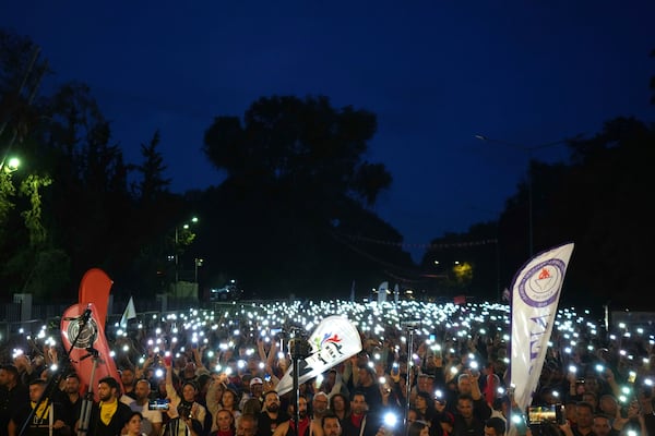 Turkish Cypriot protesters hold the lighted mobile phones aloft as they gather to protest against what they say is Turkey's attempt to erode their secular roots and to strengthen the hold of political Islam over their society, in the northern half of ethnically divided Cyprus' capital Nicosia, on Friday, May 2, 2025. (AP Photo/Petros Karadjias)