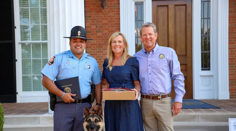 Gov. Brian Kemp and First Lady Marty Kemp pose with Rex, a dog she helped recruit for the state’s K-9 program. File.
