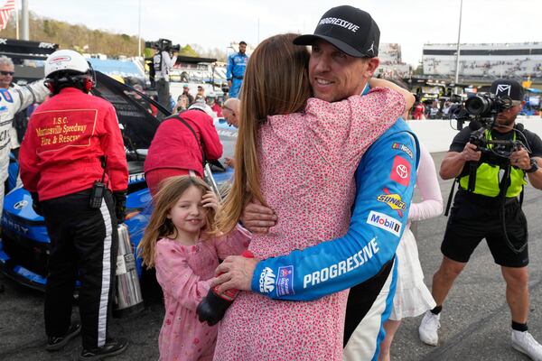 Denny Hamlin, right, hugs his fiance Jordan Fish, left, after winning a NASCAR Cup Series auto race in Martinsville, Va., Sunday, March 30, 2025. (AP Photo/Chuck Burton)