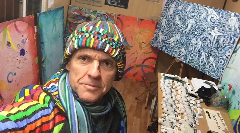 Olympian and artist Roald Bradstock of Marietta bundles up against the cold in the athletes village at the Pyeongchang Olympics — wearing his own hand-painted cap and jacket. Bradstock is helping bring art to the Olympics by engaging the athletes of the 2018 Winter Games in creating 15 collaborative canvases. CONTRIBUTED BY ROALD BRADSTOCK