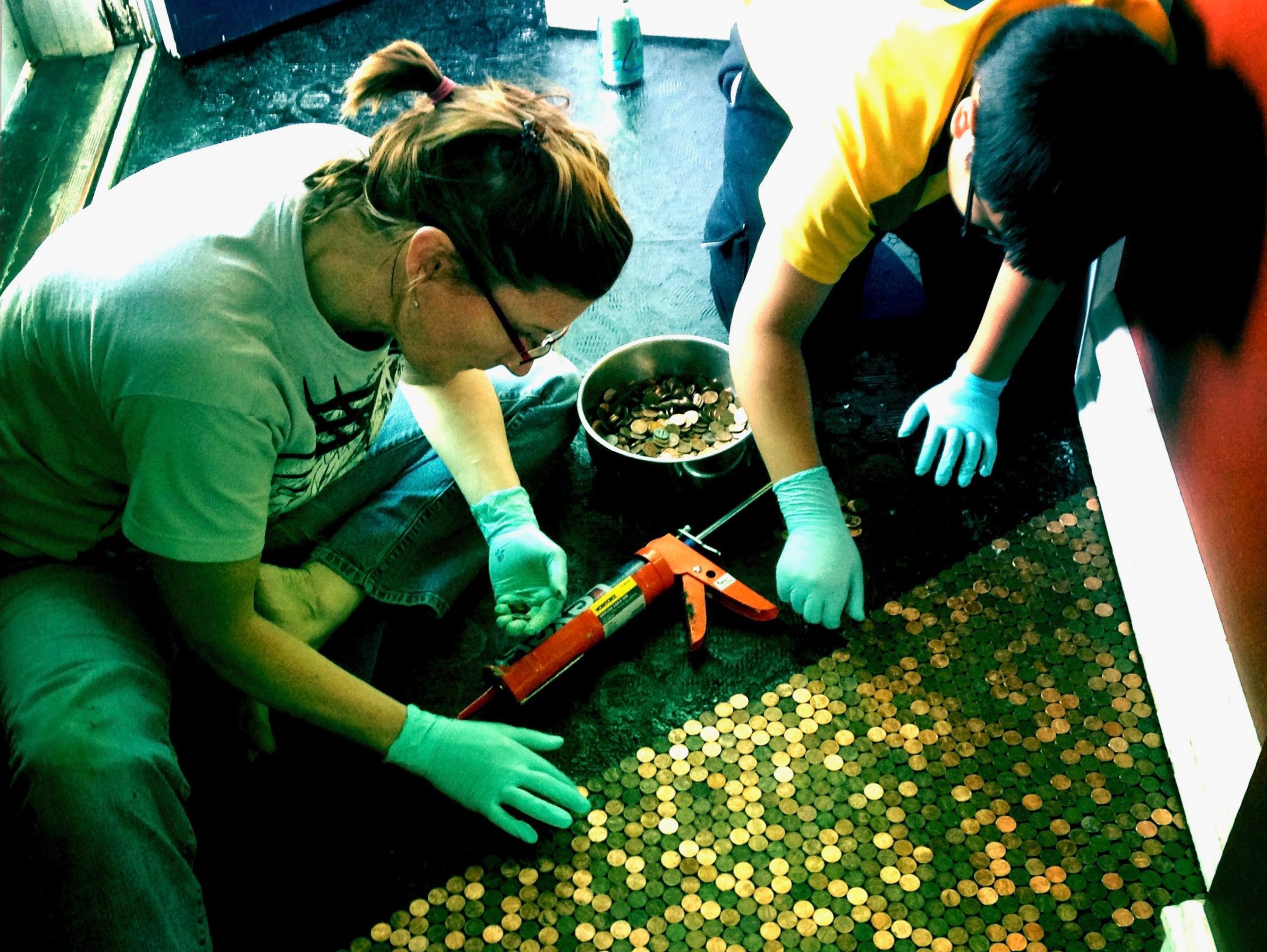 Karas Cahill decided to do something with her vast jar of pennies. So she and her son, Angelo, over the course of a couple weeks, glued 10,738 to the floor of her front hallway. (Courtesy of Karas Cahill)