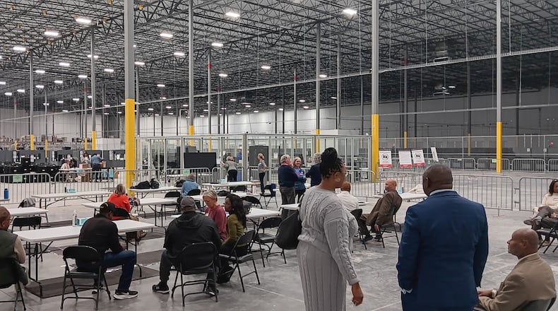 Observers and candidates watch county election staff from a public viewing area in the new Fulton elections warehouse in Union City. County workers are recounting results from the 2023 municipal elections.