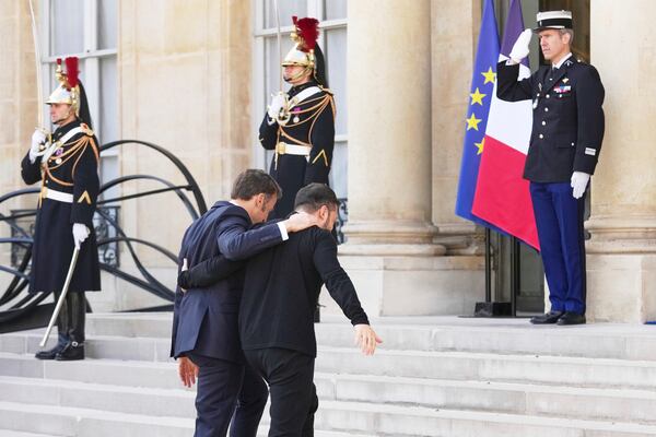 French President Emmanuel Macron, center left, walks with Ukraine's President Volodymyr Zelenskyy, center right, during arrivals for a summit on Ukraine at the Elysee Palace in Paris, Thursday, March 27, 2025 . (AP Photo/Thibault Camus)