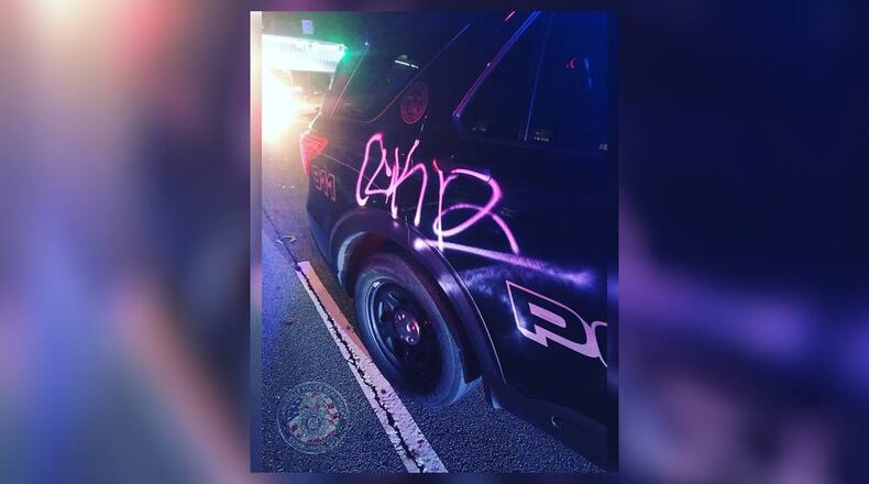 Police say six patrol cars were vandalized Saturday.