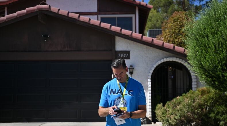 Paul Peterman of National Association of Letter Carriers checks his notes as he canvasses on Saturday, Sept. 12, 2026, in Las Vegas. (AP Photo/David Becker)