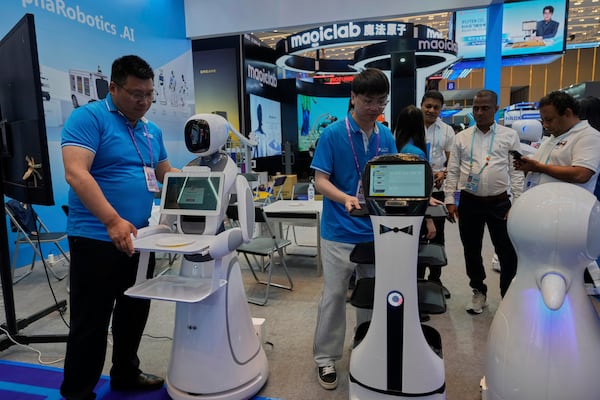 FILE - Vendors from AlphaRobotics.AI show off service robots at the 137th Canton Fair in Guangzhou in southern China's Guangdong province on April 16, 2025. (AP Photo/Ng Han Guan, File)