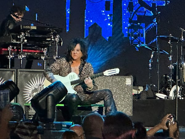 Steve Stevens — resplendent in leopard skin, leather pants and big hair — supported Billy Idol with hearty guitar work. (Rodney Ho/AJC)
