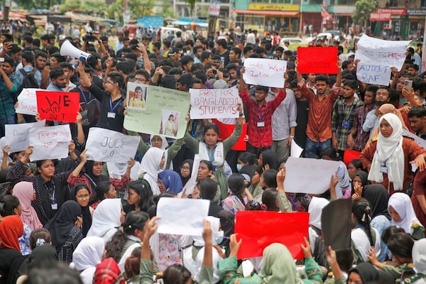 Students shout slogans during a protest near the site of the Monday crash of a Bangladesh air force training jet into a school, demanding accountability, compensation for victims' families and the halt of training flights, in Dhaka, Bangladesh, Tuesday, July 22, 2025. (AP Photo/ Mehedi Hasan)