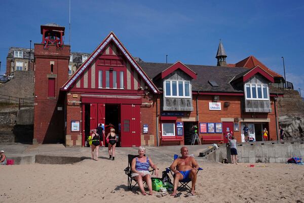 People enjoy the hot weather at Cullercoats Beach in North Shields, England, Friday, June 20, 2025. (Owen Humphreys/PA via AP)
