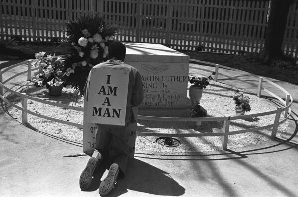 A striking Atlanta sanitation worker kneels at the grave of the Rev. Martin Luther King Jr. after a Southern Christian Leadership Conference rally supporting the strike in Atlanta on April 4, 1970. King was killed in Memphis, Tenn., two years earlier while supporting a sanitation workers’ strike there. The picket signs reading “I Am A Man” were first used in the Memphis strike. (AP file)