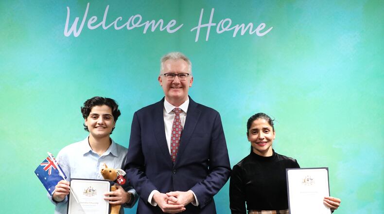 FILE - Fatemeh Pasandideh, left, and Atefeh Ramezanisadeh, right, former members of the Iranian women's soccer team, stand with Australia's Minister for Home Affairs, Tony Burke, after receiving their citizenship in Brisbane, Australia, on Aug. 5, 2026. (Department of Home Affairs via AP, File)