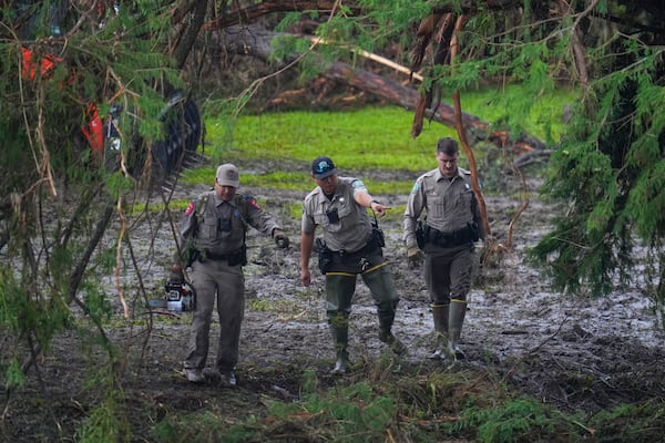 Officials inspect an area at Camp Mystic along the banks of the Guadalupe River after a flash flood swept through the area Sunday, July 6, 2025, in Hunt, Texas. (AP Photo/Julio Cortez)