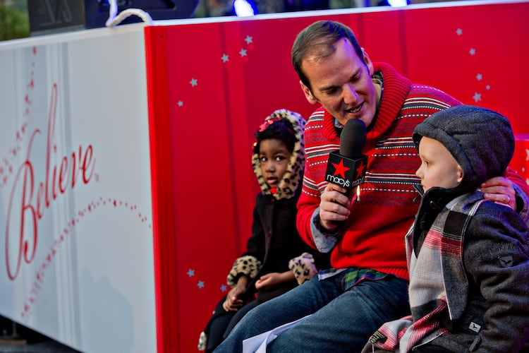 Emcee Cadillac Jack (center) interviews Carson Sims (right) and McKinley Parks during the annual Macy's Great Tree Lighting celebration at Lenox Square Mall in Atlanta, Nov. 27, 2014. (Jonathan Phillips for the AJC)