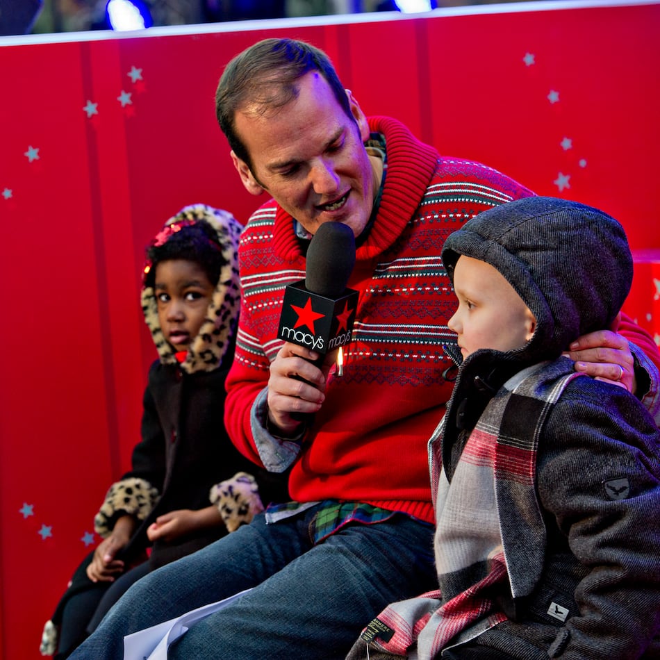 Emcee Cadillac Jack (center) interviews Carson Sims (right) and McKinley Parks during the annual Macy's Great Tree Lighting celebration at Lenox Square Mall in Atlanta, Nov. 27, 2014. (Jonathan Phillips for the AJC)