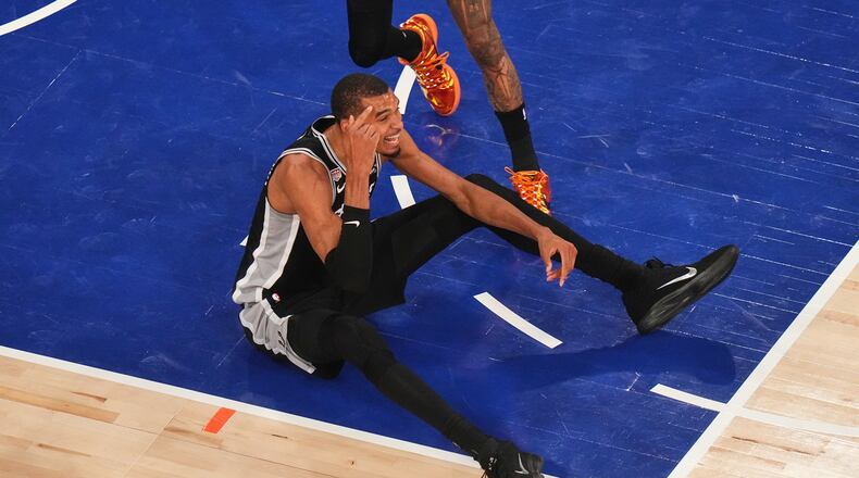 San Antonio Spurs forward Victor Wembanyama sits on the court after being knocked down during the first half of Game 4 of the NBA Finals basketball series against the New York Knicks, Wednesday, June 10, 2026, in New York. (AP Photo/Frank Franklin II)