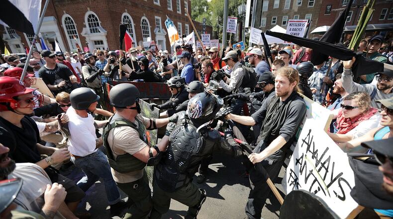 White nationalists, neo-Nazis and members of the alt-right clash with counter-protesters as they enter Lee Park during the ‘Unite the Right’ rally August 12, 2017, in Charlottesville, Va. After clashes with anti-fascist protesters and police the rally was declared an unlawful gathering. CHIP SOMODEVILLA / GETTY IMAGES