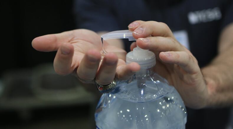 Aaron Sones uses hand sanitizer during the Construction Education Foundation of Georgia (CEFGA) career expo on Thursday, March 12, at the Georgia World Congress Center. This year, additional safety measures were implemented to guard against the coronavirus. (Christina Matacotta, for The Atlanta Journal-Constitution).