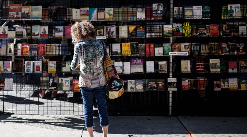 A woman reads a book at the 12th Annual AJC Decatur Book Festival last year. CONTRIBUTED BY BRANDEN CAMP