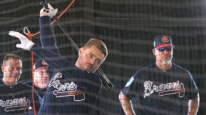 Braves first baseman Freddie Freeman takes swings in the batting cage as former teammate and recently elected Hall of Fame third baseman Chipper Jones watches at the team’s spring training complex in Lake Buena Vista, Fla.