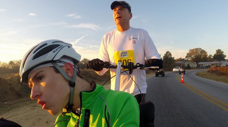 The early morning sun hits Rich and Kevin Enners as they run the first miles of the Albany Marathon on Saturday March 7, 2015.