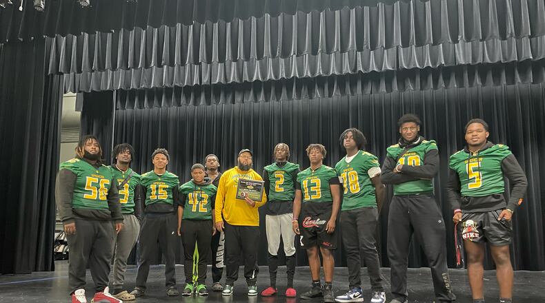 The Spencer Greenwave Owls senior class and coach Joe Kegler are pictured with GHSF Daily's Team of the Week award plaque at the school on Wednesday, Oct. 26, 2022, after their win over Northeast the previous Friday. (Adam Krohn/for the AJC)