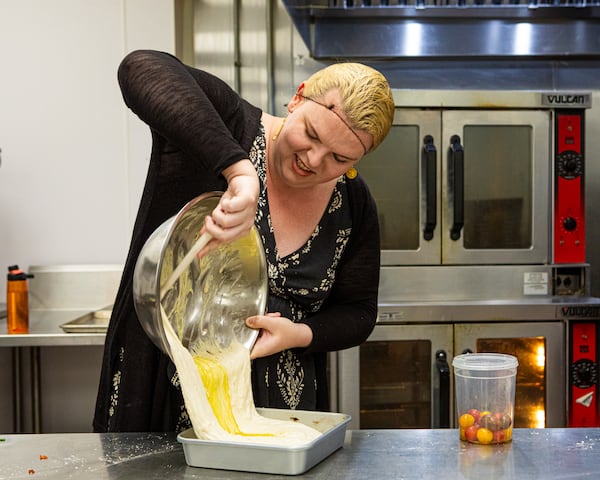Rose Gates of Hi Honey Bakery prepares focaccia made with ripe cherry tomatoes. Gates took up baking in 2023 as a form of therapy after a series of life setbacks. (Aaliyah Man for the AJC)