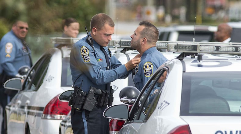 10/23/2018 — Peachtree Corners, Georgia — A Gwinnett County police officer makes sure his colleague’s uniform is in good order before they enter the Crowell Brothers Funeral Home for the visitation of slain Gwinnett County police officer Antwan Toney in Peachtree Corners. Officer Toney was allegedly shot and killed by 18-year-old Tafahree Maynard on Saturday. A three day man hunt ensued. Tafahree Maynard was located by authorities on Monday and was shot and killed after not complying with commands. (ALYSSA POINTER/ALYSSA.POINTER@AJC.COM)