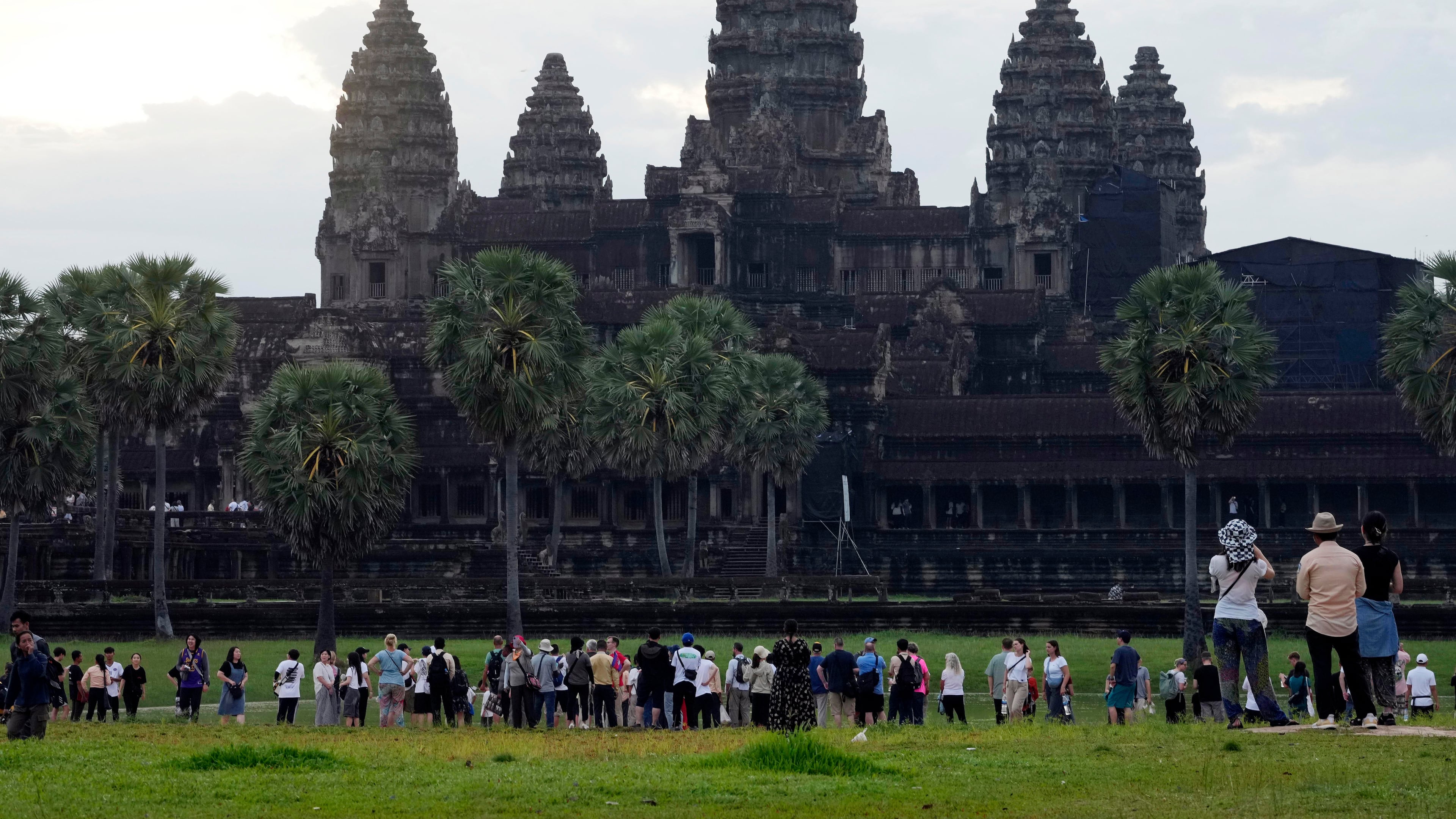 FILE - Tourists wait for sunrise at the Angkor Wat temple in Siem Reap province, Cambodia, Friday, Aug. 2, 2024. (AP Photo/Heng Sinith, File)