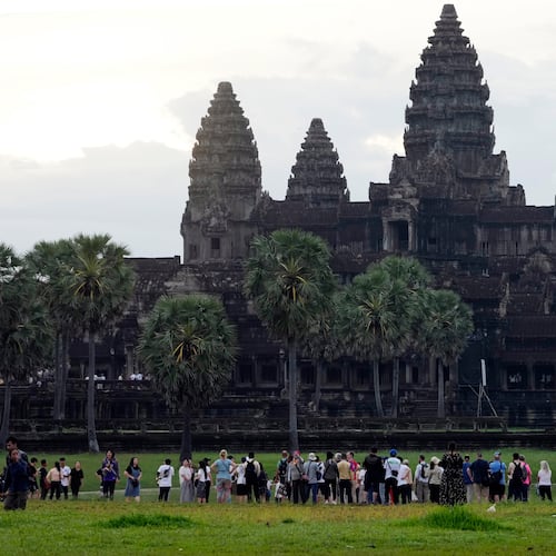 FILE - Tourists wait for sunrise at the Angkor Wat temple in Siem Reap province, Cambodia, Friday, Aug. 2, 2024. (AP Photo/Heng Sinith, File)