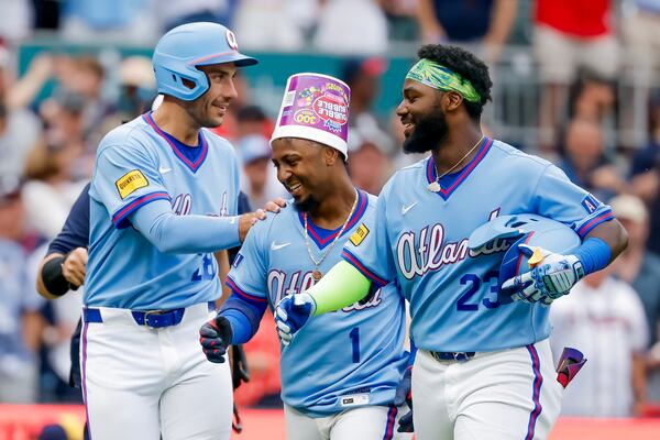 Bucket-headed second baseman Ozzie Albies (center) celebrates Saturday's walk-off home run with Matt Olson (left) and Michael Harris II. (Erik S. Lesser/AP)
