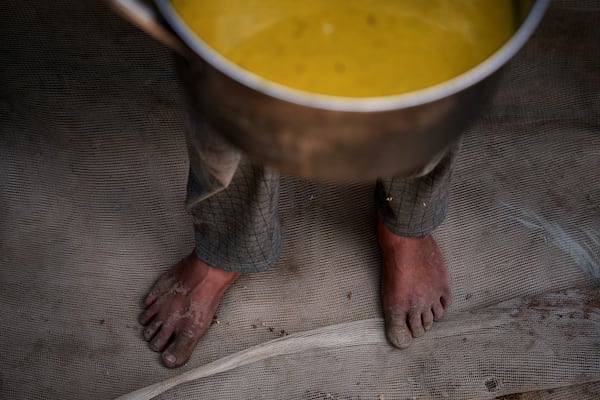 A Palestinian child carries a pot of soup received from a community kitchen in Khan Younis, Gaza Strip, on Saturday, May 3, 2025. (AP Photo/Abdel Kareem Hana)