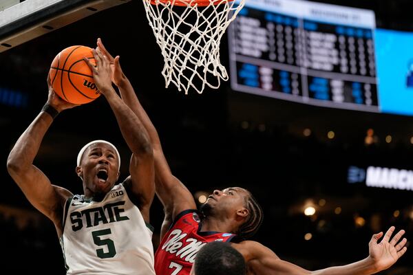 Michigan State guard Tre Holloman (5) shoots against Mississippi guard Davon Barnes (7) during the second half in the Sweet 16 of the NCAA college basketball tournament, Friday, March 28, 2025, in Atlanta. (AP Photo/George Walker IV)