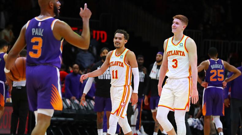 Hawks guard Trae Young smiles at Suns guard Chris Paul, with Kevin Huerter looking on, in the final minute of a 124-115 victory over the Suns. (Curtis Compton / Curtis.Compton@ajc.com)