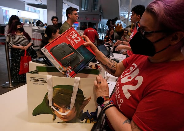 A Nintendo store cashier places a Switch 2 in a bag for a customer at the Nintendo store in New York's Rockefeller Center, Thursday, June 5, 2025. (AP Photo/Richard Drew)