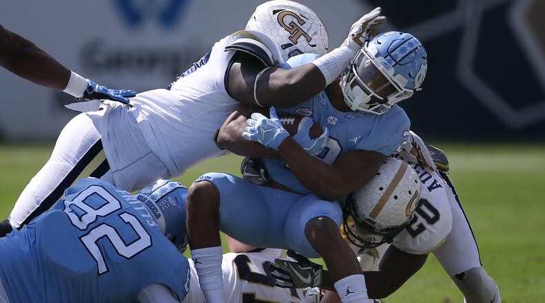 North Carolina running back Jordon Brown (2) is tackled by Georgia Tech linebacker Brant Mitchell (51) and Georgia Tech defensive back Lawrence Austin (20) in the first half of an NCAA college football game Saturday, Sept. 30, 2017, in Atlanta. (AP Photo/John Bazemore)