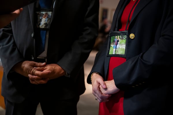 Tim and Sheri Lilley wear photos of Sam on the first day of the NTSB investigative hearing. Many family members in attendance wore images of their loved ones like this throughout the more than 30 hours of testimony. (Craig Hudson for the AJC)