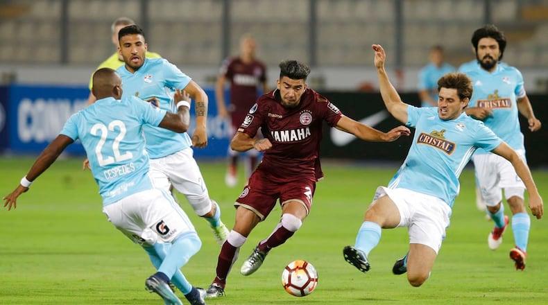 Marcelino Moreno of Argentina's Lanus, center, fights for the ball, surrounded of players of Peru's Sporting Cristal during a Copa Sudamericana soccer match in Lima, Peru, Wednesday, March 7, 2018. (AP Photo/Martin Mejia)
