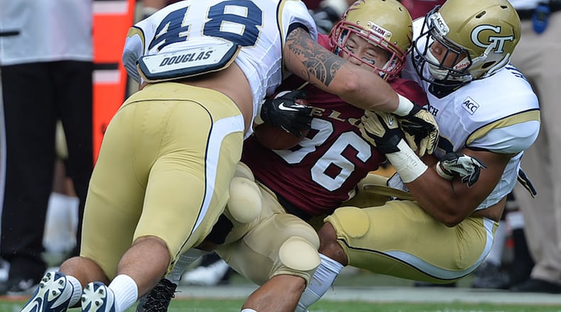 Georgia Tech's Nick Menocal (48) and Beau Hankins (33) tackle Thuc Phan (36) for a loss of 2 yards during the Jackets' 70-0 win over Elon on Saturday, Aug. 31, 2013, at Bobby Dodd Stadium .