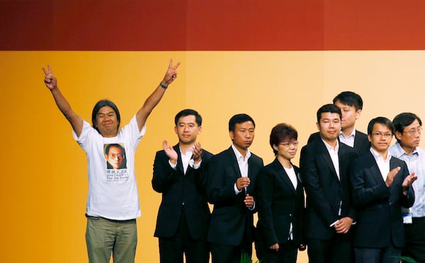 FILE - Leung Kwok-hung, also known as "Long Hair," left, of the pro-democracy League of Social Democrats celebrates after winning a seat on the Legislative Council next to Chan Hak-kan, second from right, of the pro-Beijing Democratic Alliance for the Betterment of Hong Kong Party in Hong Kong, on Sept. 10, 2012. (AP Photo/Kin Cheung, File)