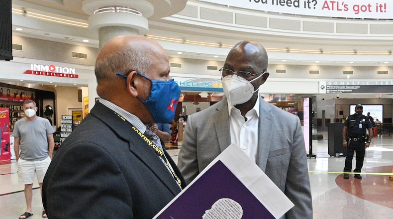 Balram Bheodari (left), General Manager of Hartsfield-Jackson Atlanta International Airport talks with Dwayne Mitchell, artist, during an event to announce the exhibition of the Atlanta Children's Memorial Portraits at Hartsfield-Jackson Atlanta International Airport on Wednesday, June 30, 2021. (Hyosub Shin / Hyosub.Shin@ajc.com)