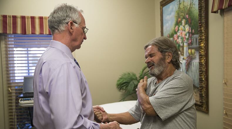 Tony Bernhardt, 74, winced in pain during his visit with Dr. John Downey in Augusta on Oct. 24. Bernhardt was looking for alternatives to surgery. Downey credits Georgia’s Prescription Drug Monitoring Program or PDMP with helping reduce drug overdose deaths in Georgia. (Alyssa Pointer/Atlanta Journal Constitution)