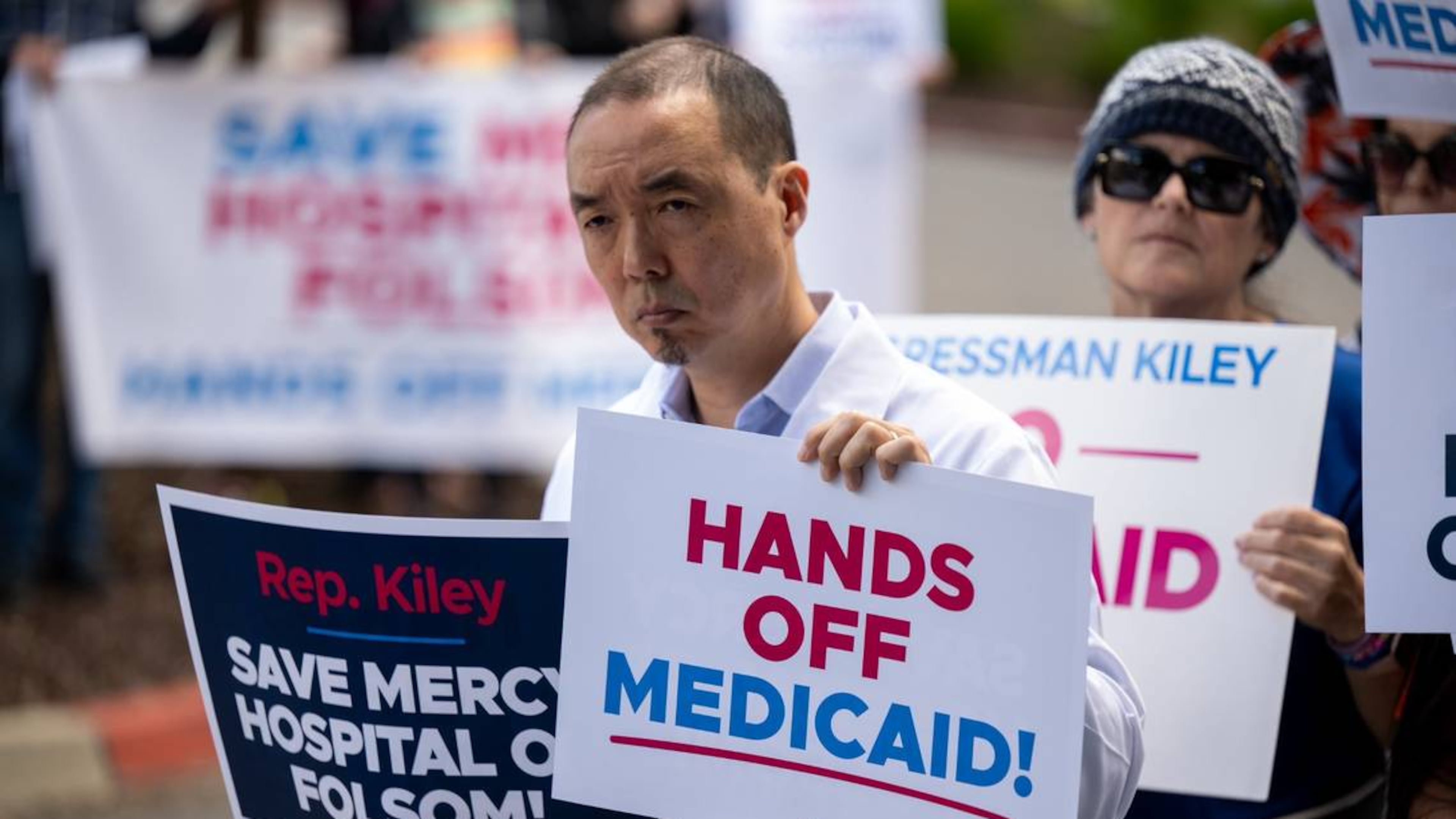 Dr. Ian Kim holds signs protesting potential cuts to Medicaid during a "Save Our Hospitals" rally at Dignity Health Mercy Hospital in Sacramento County, California, on May 13, 2025. (Paul Kitagaki Jr./The Sacramento Bee)