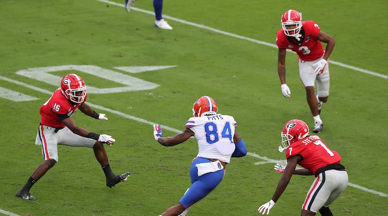110720 Jacksonville: Georgia defenders Lewis Cine (clockwise from left), Tyson Campbell, and Tyrique Stevenson look to stop Florida tight end Kyle Pitts during the first half in a NCAA college football game on Saturday, Nov 7, 2020, in Jacksonville.   “Curtis Compton / Curtis.Compton@ajc.com”