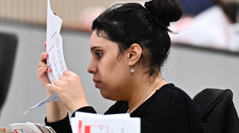 A worker inspects a ballot at the L.A. County Ballot Processing Center during the California primary election on Tuesday, June 2, 2026, in City of Industry, Calif. (AP Photo/William Liang)